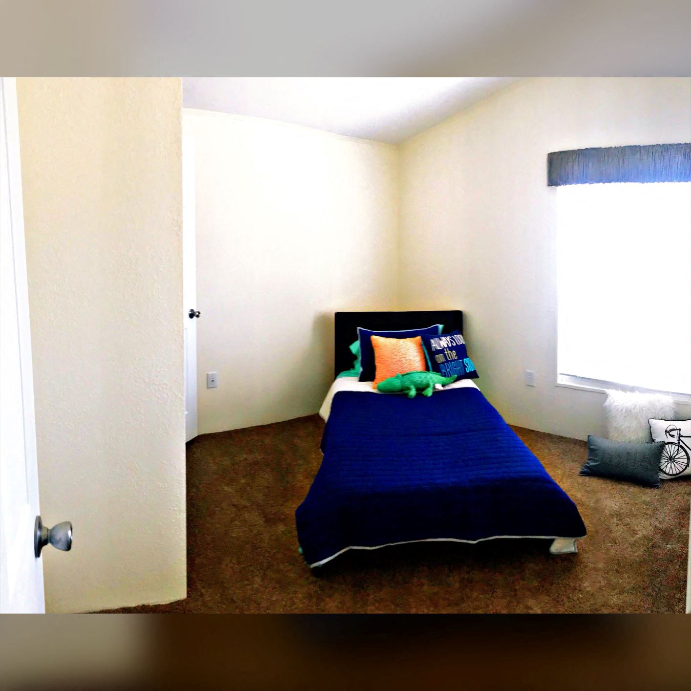 a bedroom with a blue bed and a window