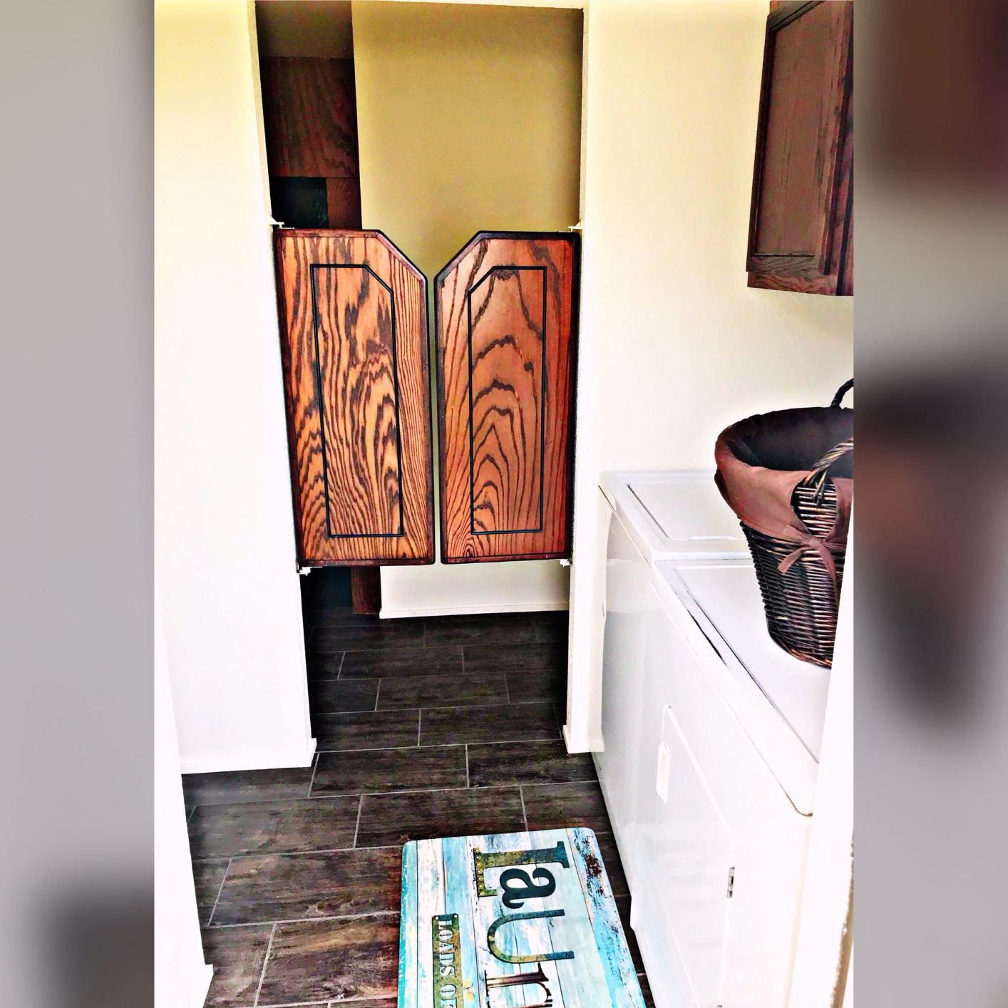 a laundry room with wooden cabinets and a washer and dryer