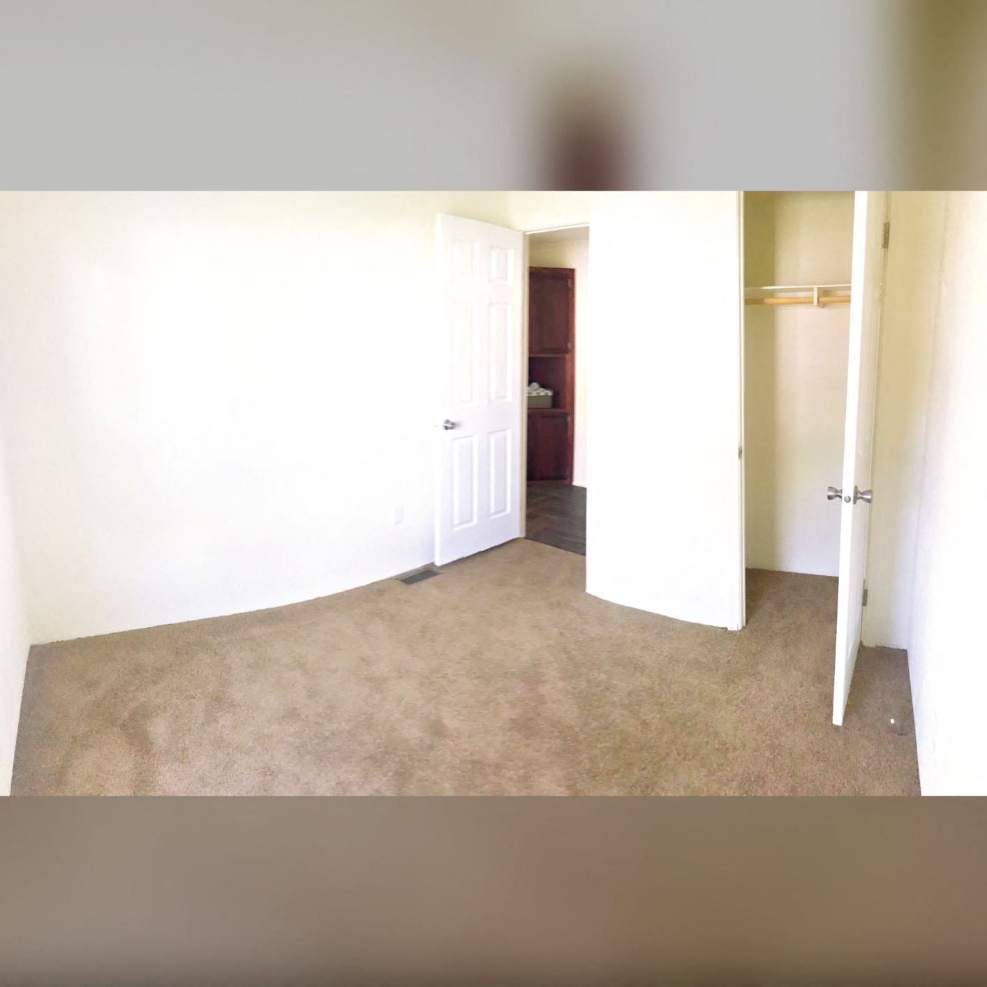 an empty room with a white door and a carpet