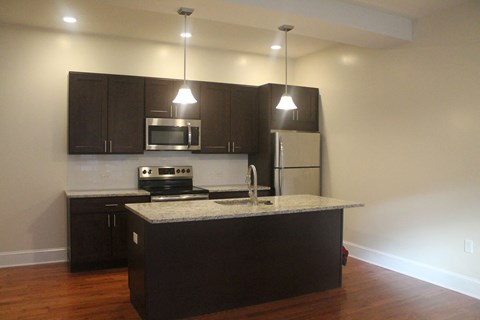 an empty kitchen with dark cabinets and a counter top