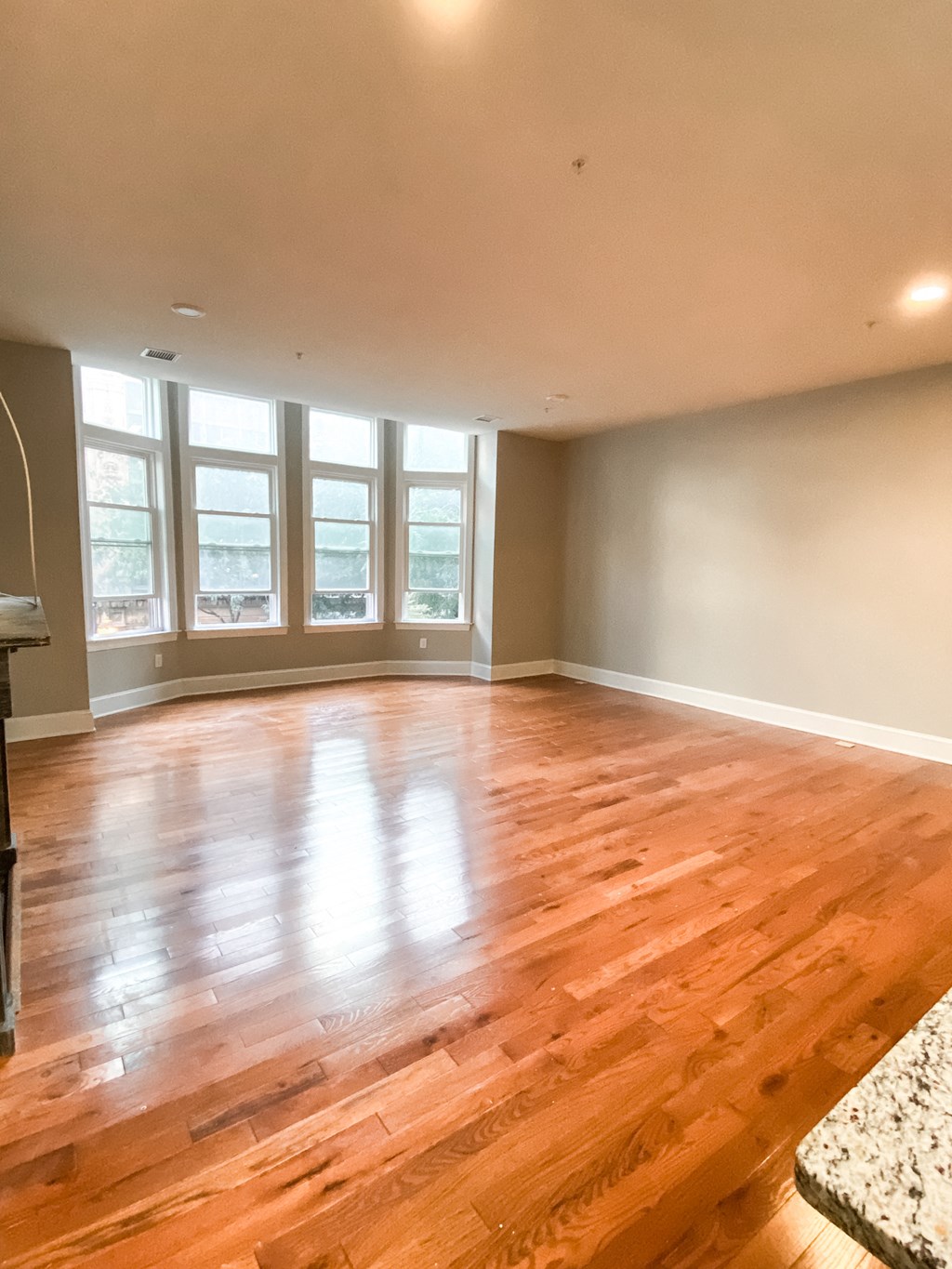 an empty living room with wood floors and windows