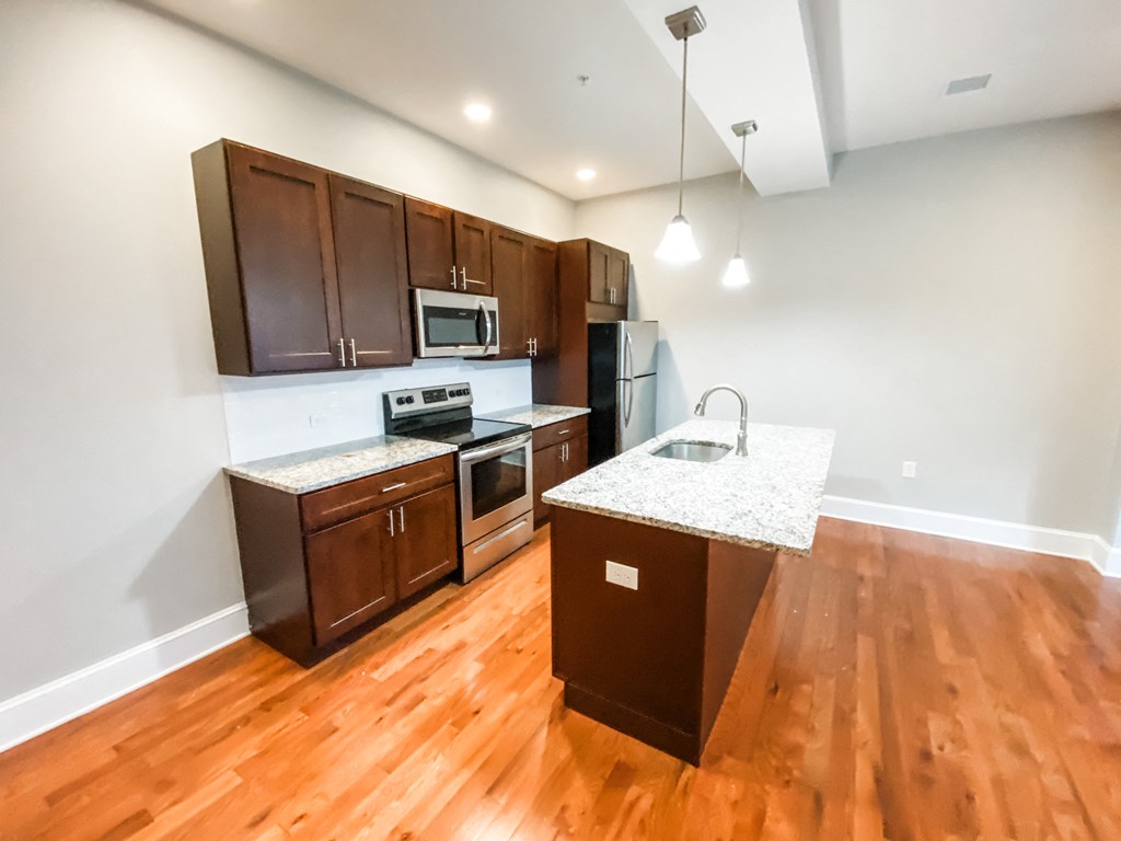 an empty kitchen with wooden floors and wooden cabinets