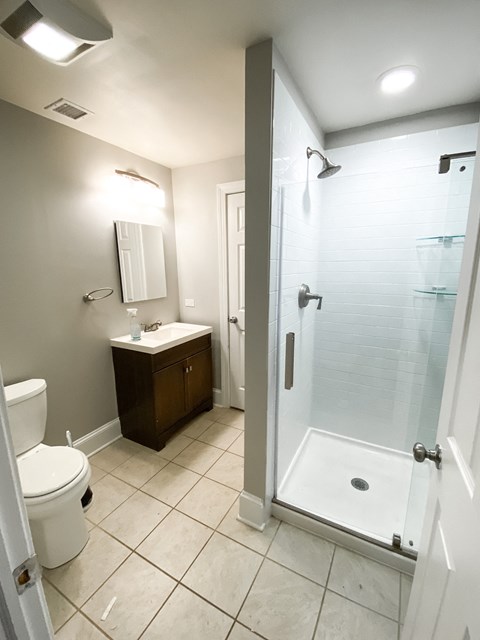 a bathroom with a shower and a sink and a toilet