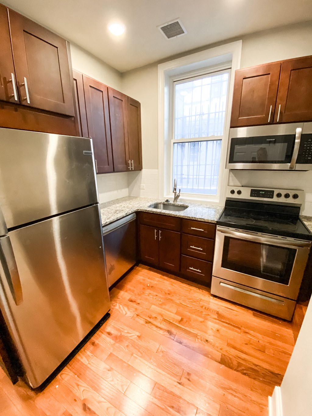 a kitchen with stainless steel appliances and wooden floors