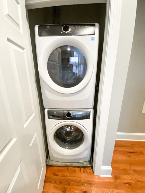 a white front load washer and dryer in a small closet