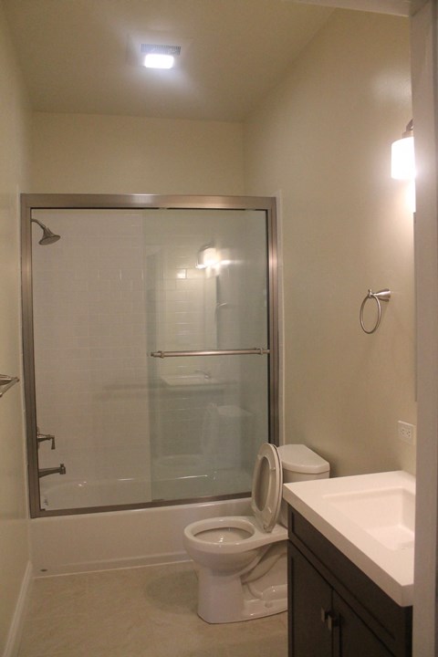 a small bathroom with a shower toilet and sink