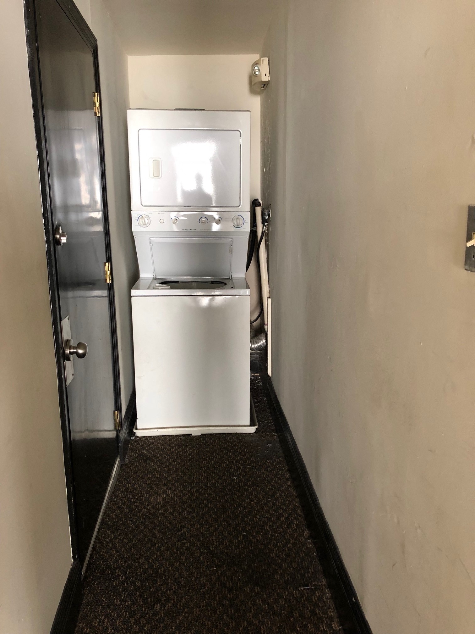 a small refrigerator and a washing machine in a small room