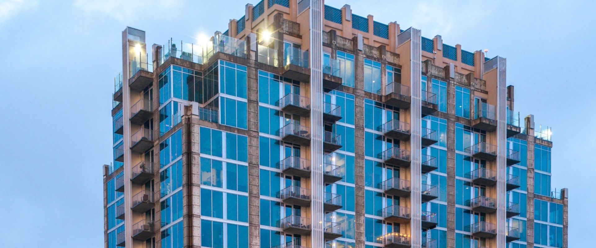 A tall building with many windows and balconies is under construction.