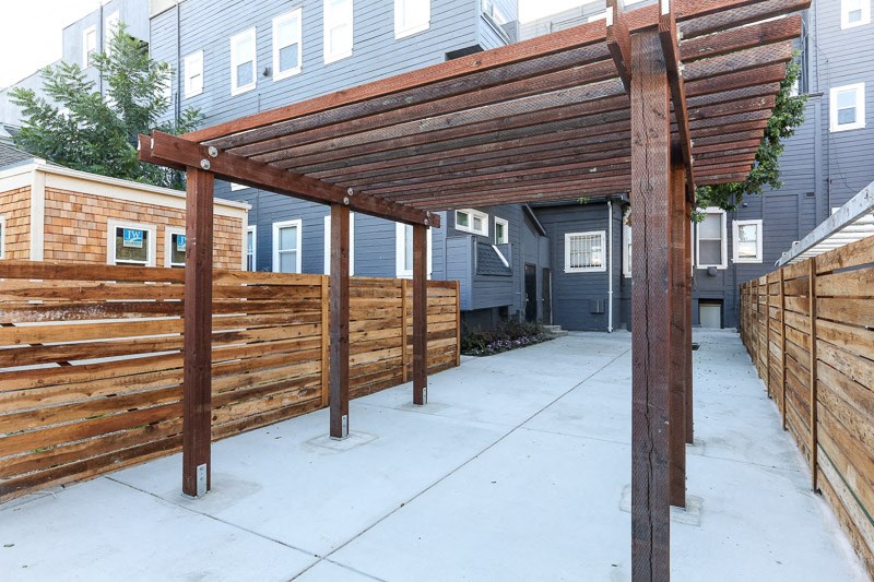 a wooden fence with a covered patio in front of a house