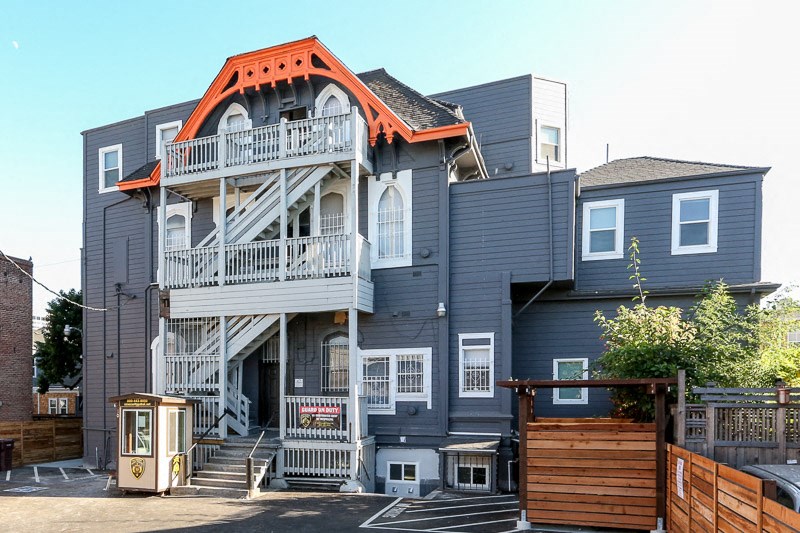 a blue house with an orange roof and stairs
