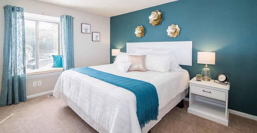 a blue and white bedroom with a bed and a window