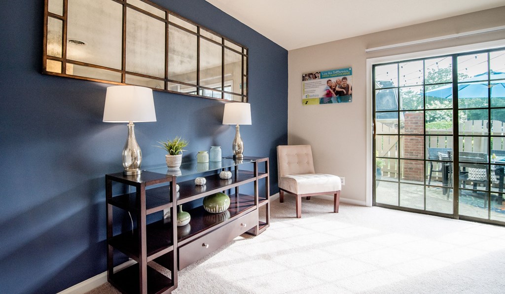 a living room with a blue accent wall and a large window