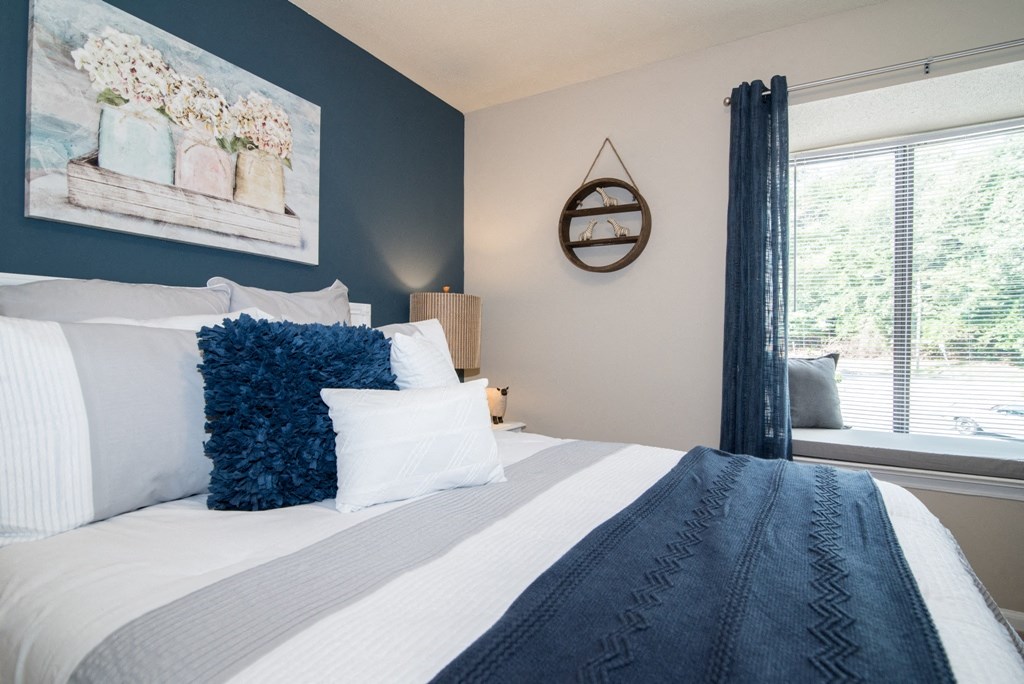 a blue and white bedroom with a bed and a window
