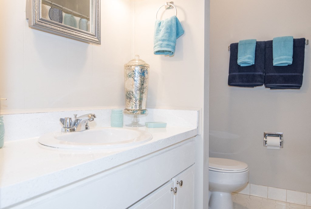 a bathroom with a sink and a toilet and blue towels