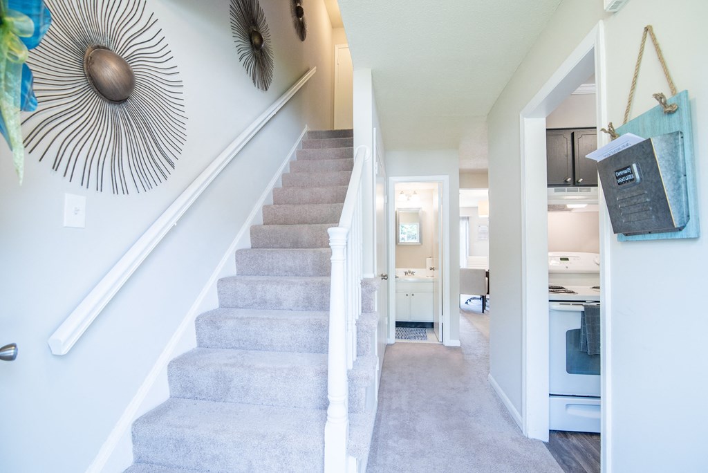 a view of the stairs in a home with a hallway and a kitchen