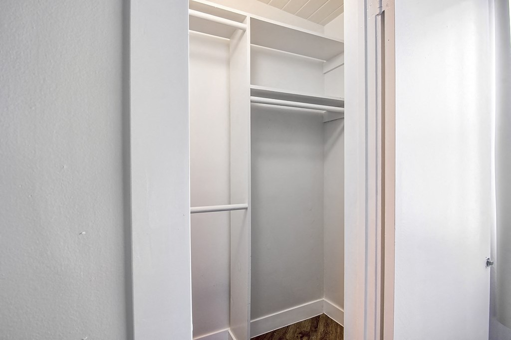 a walk in closet with white walls and a white door