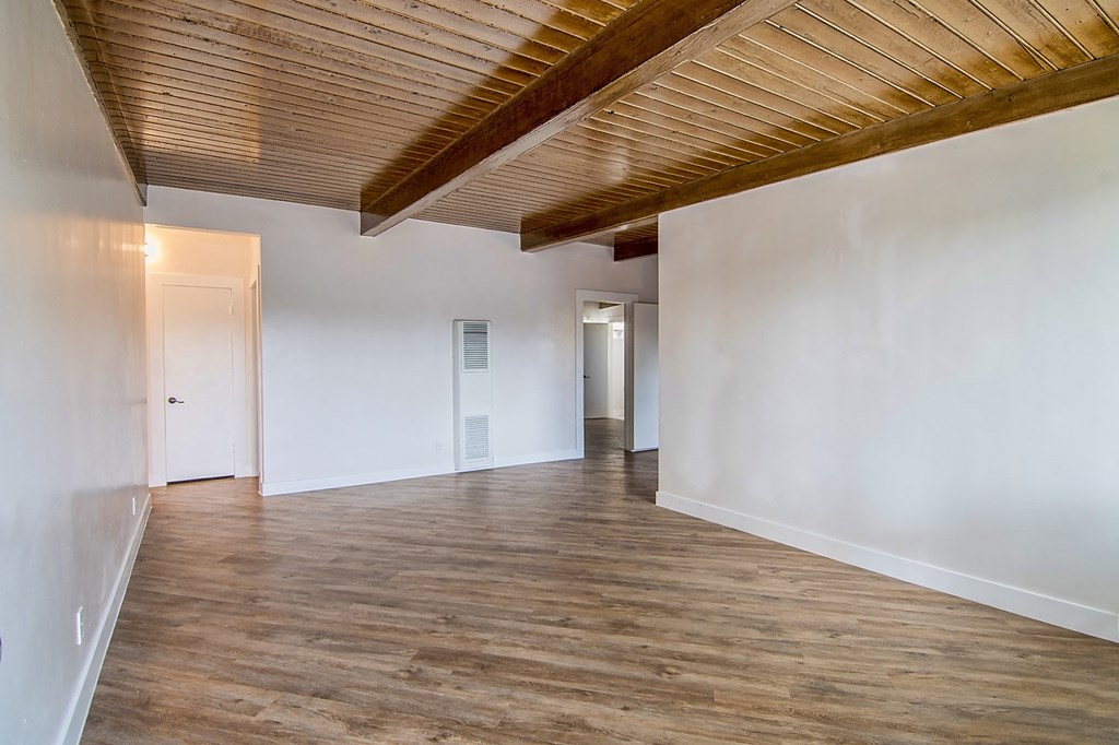 a renovated living room with white walls and wood floors