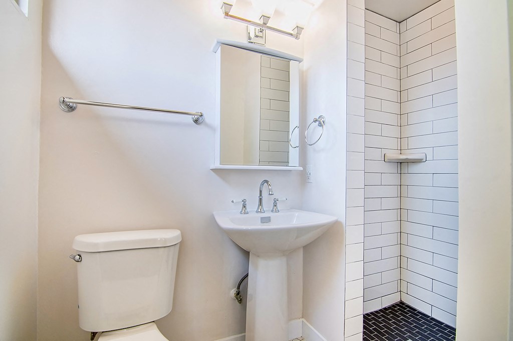 a bathroom with a sink toilet and a mirror
