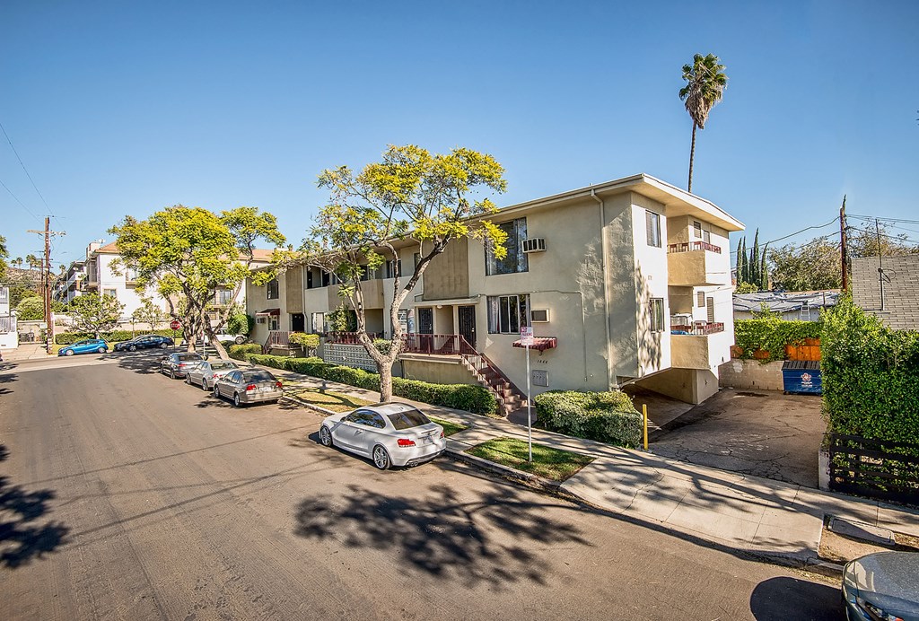 a row of houses on a street with cars parked in front