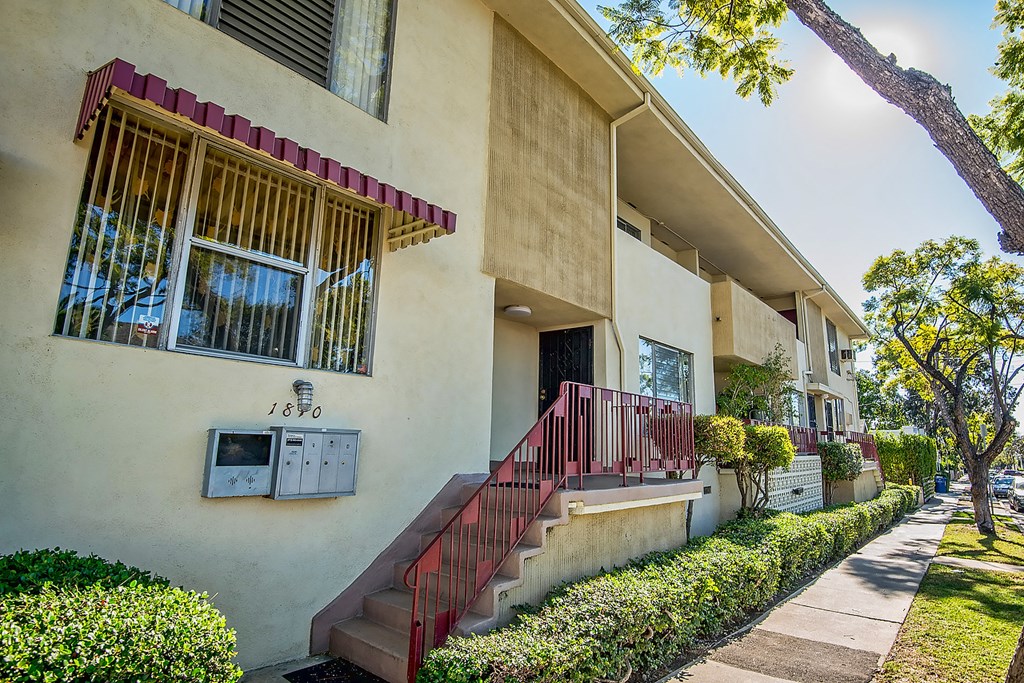 an apartment building with stairs and a window and a mailbox