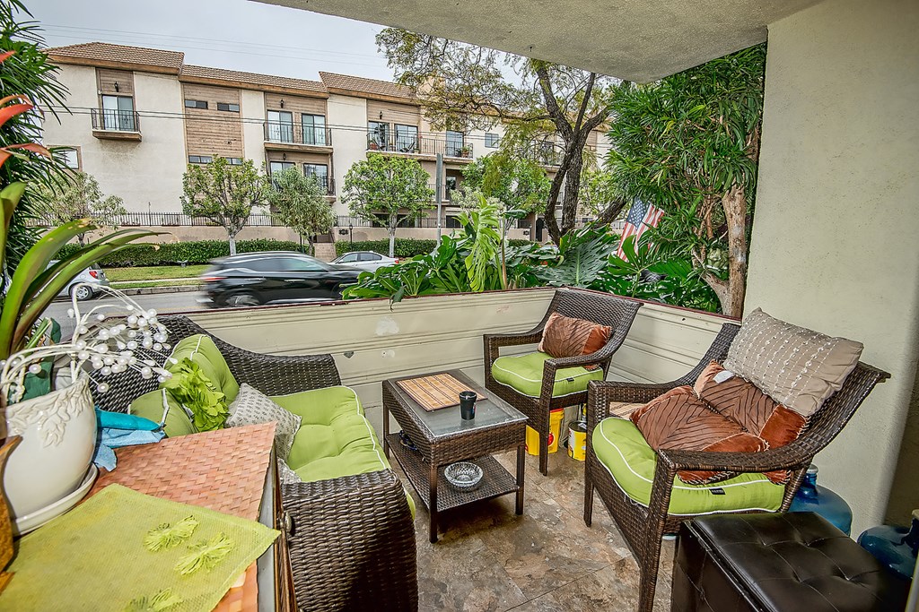 a patio with wicker chairs and a table