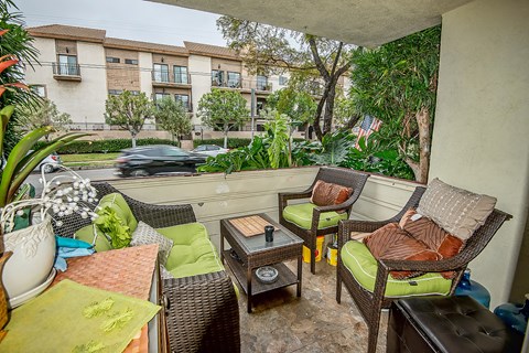 a patio with wicker chairs and a table