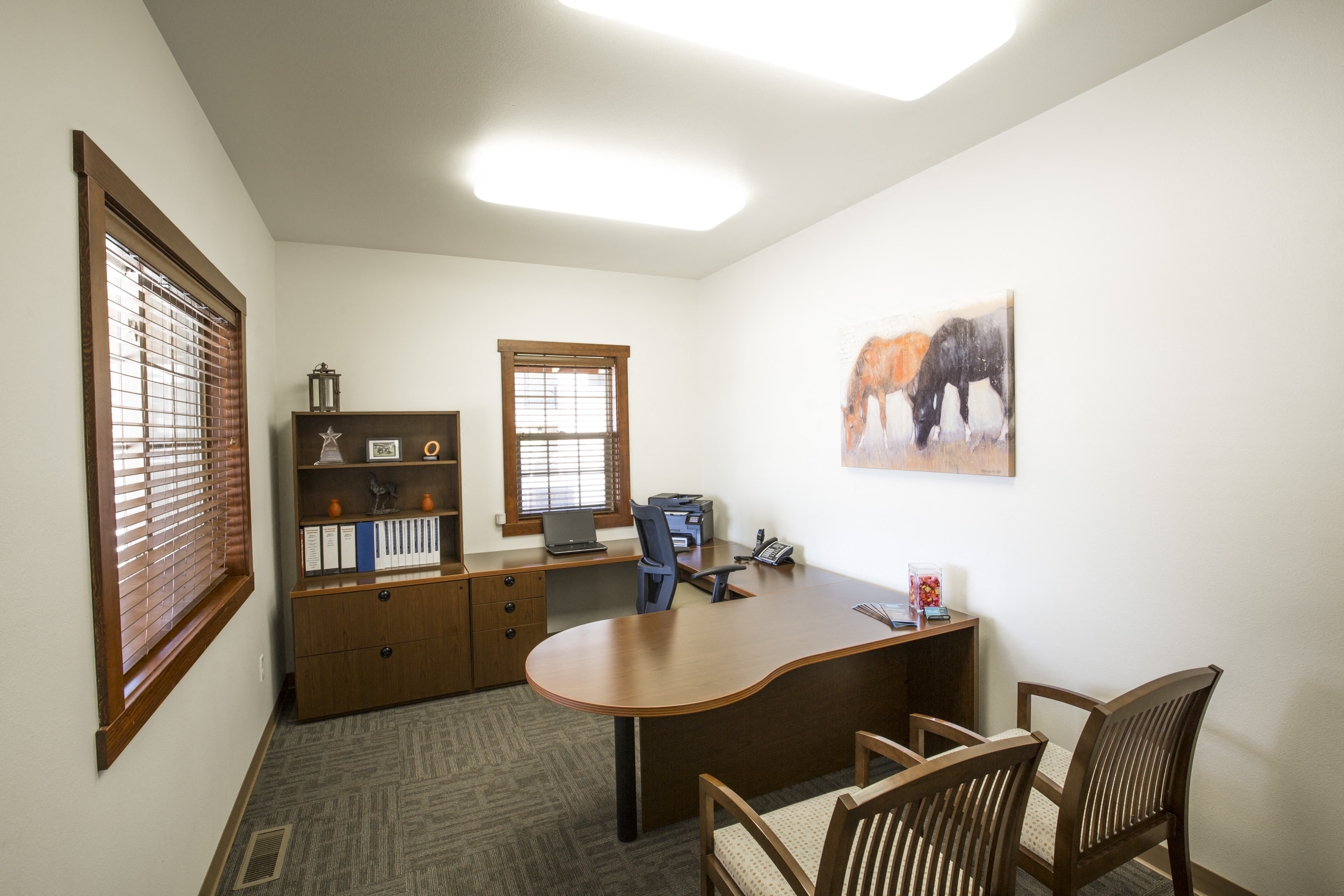 an office with a desk and a painting of an elephant