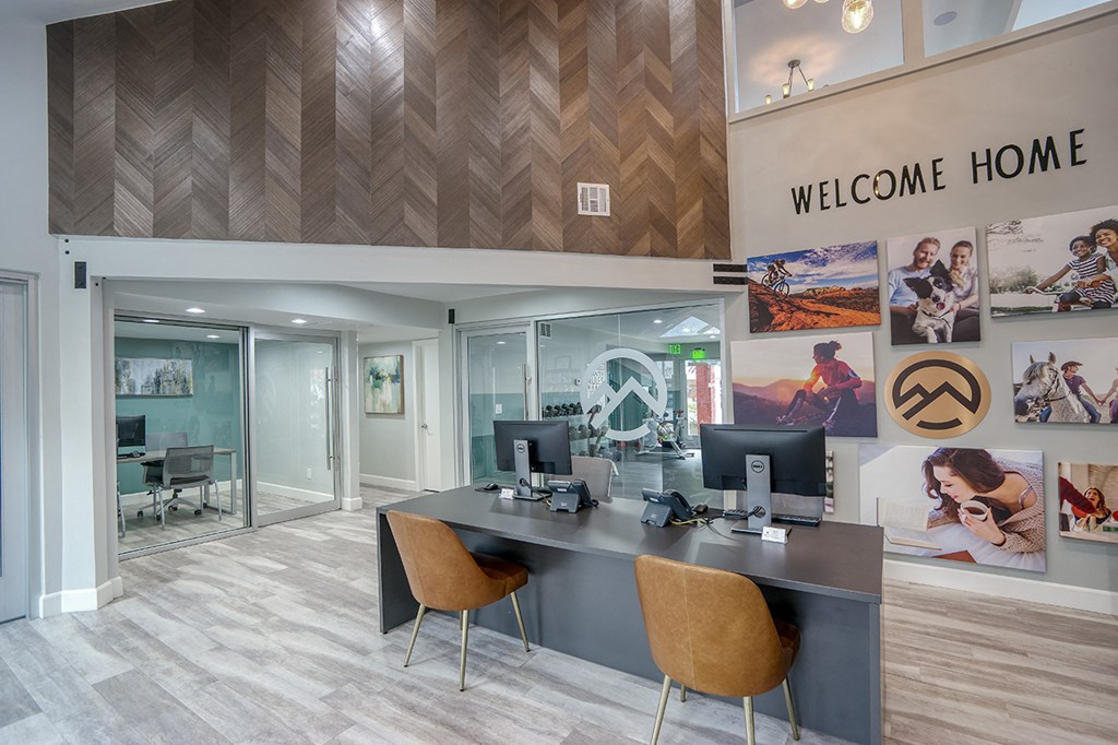 an office with a desk and chairs and a welcome home sign