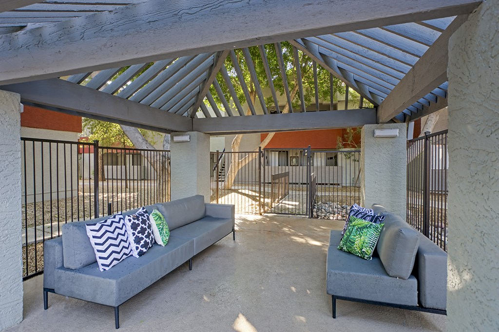 a covered patio with couches and a table