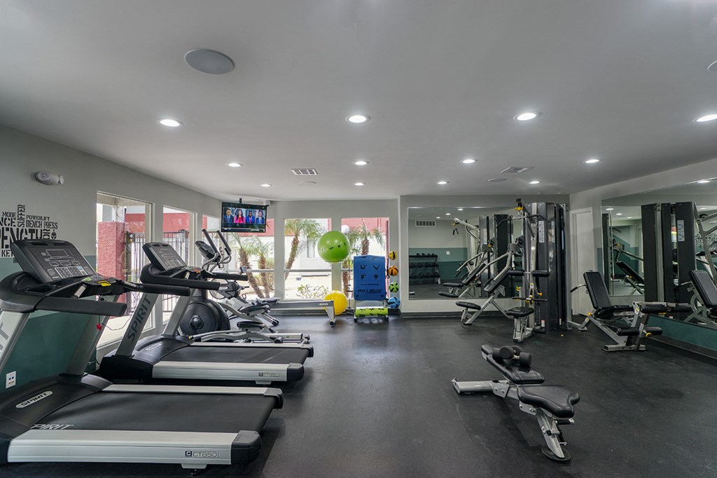 a gym with treadmills and other exercise equipment and a window