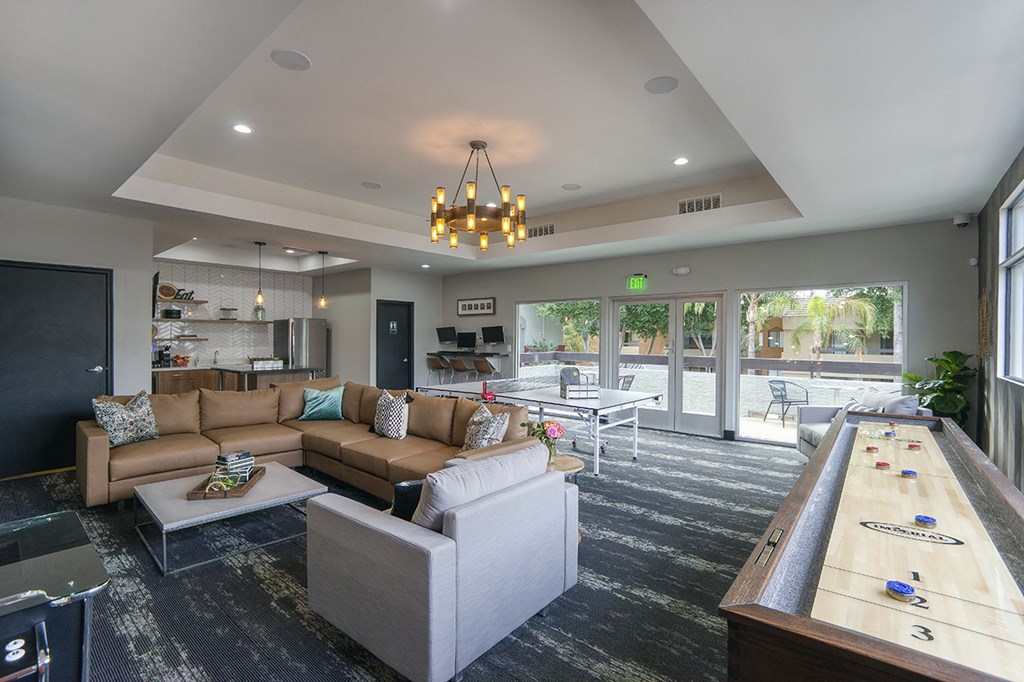 a large living room with couches and a ping pong table