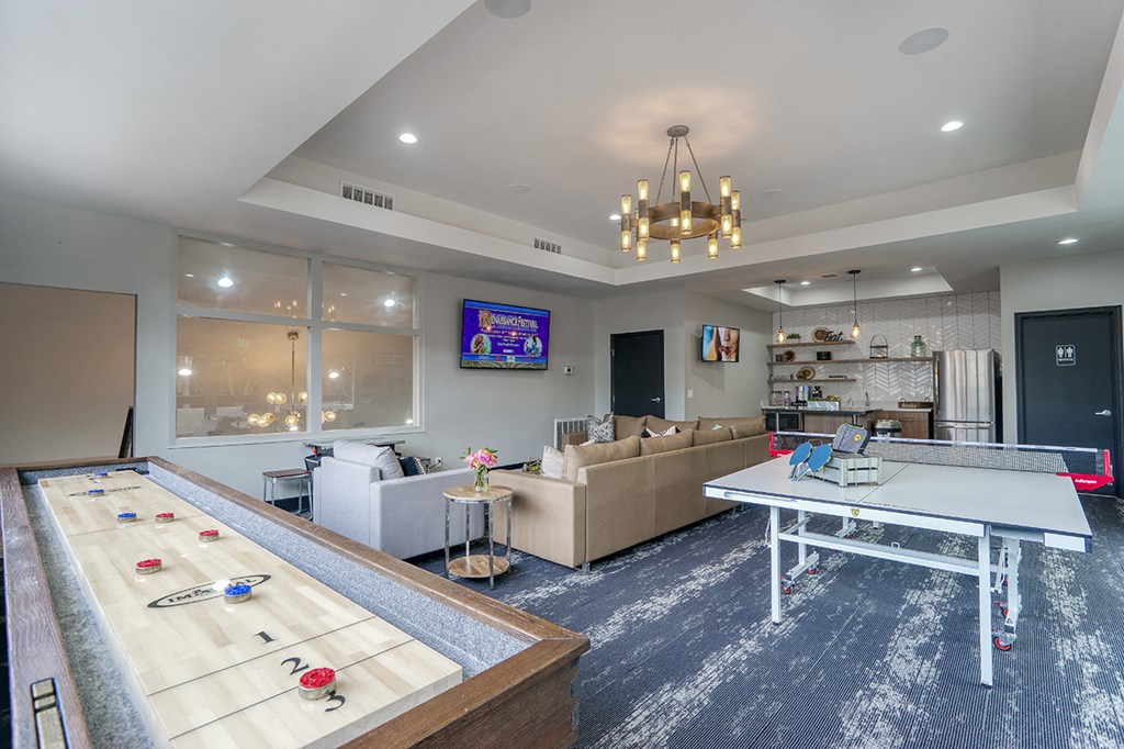 a game room with a ping pong table and a couch