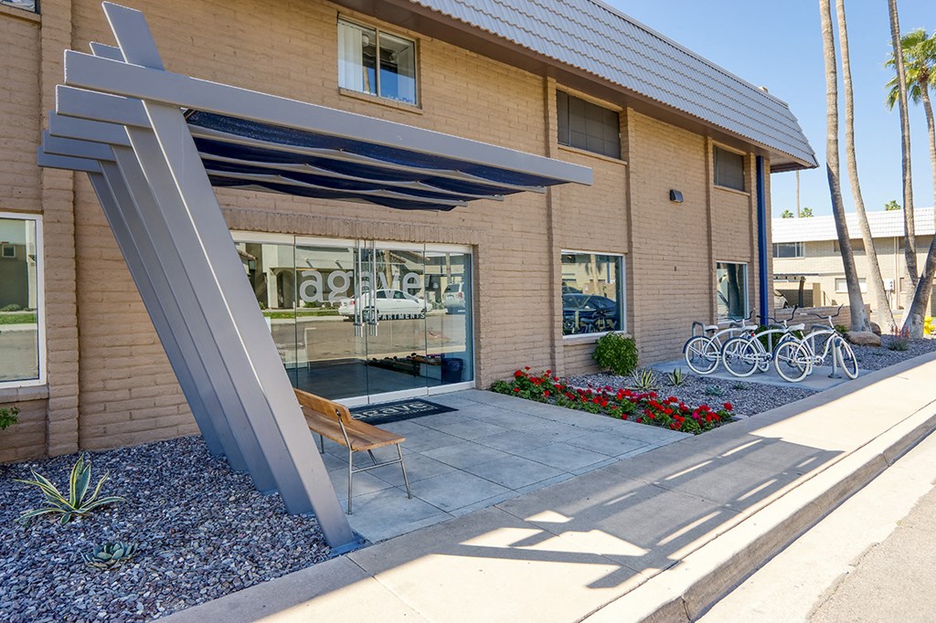 the front of a building with a patio and bikes parked outside of it