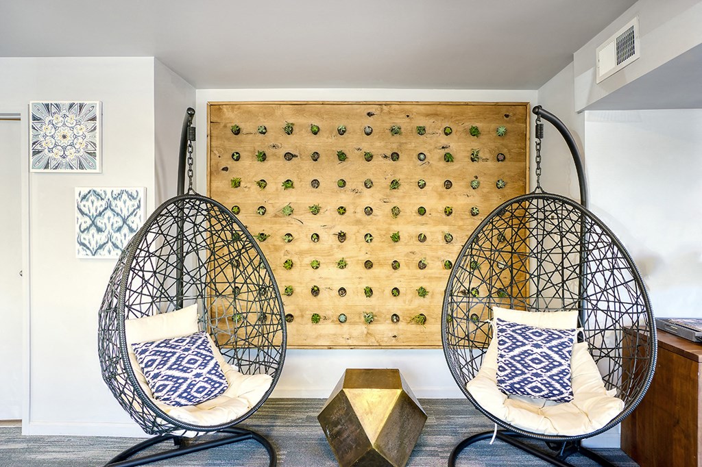 a pair of egg chairs in front of a wall with aueduedued wall