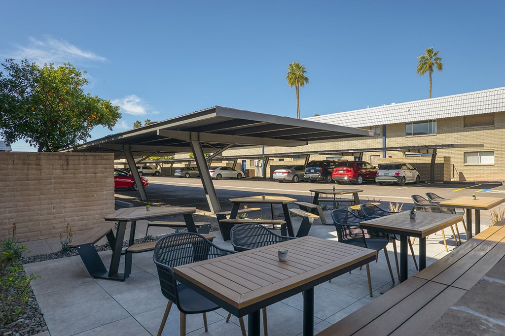 a patio with tables and chairs outside of a building