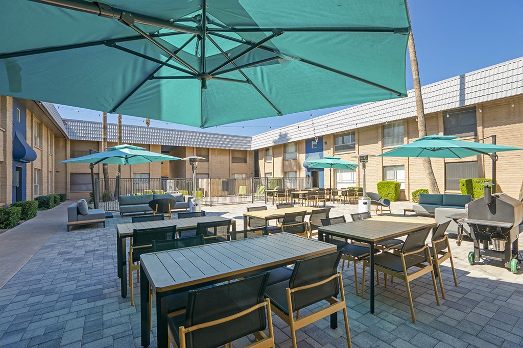 a patio with tables and chairs and umbrellas