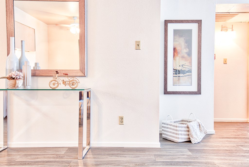 a living room with a table and a mirror