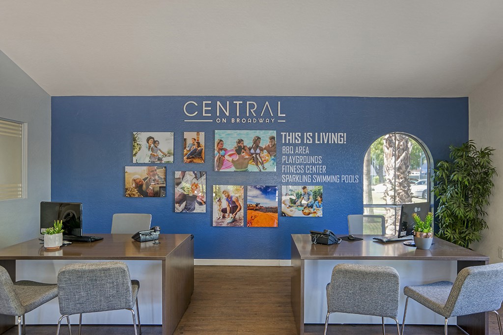 an office with desks and chairs and a blue wall with pictures on it