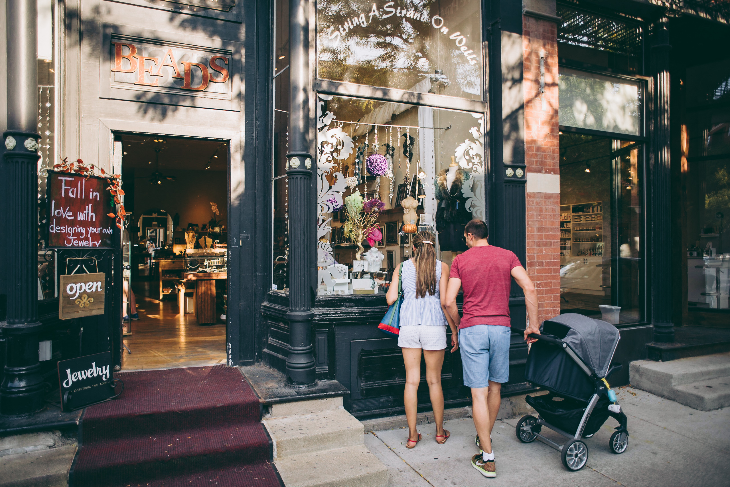 a couple walking down the street in front of a store