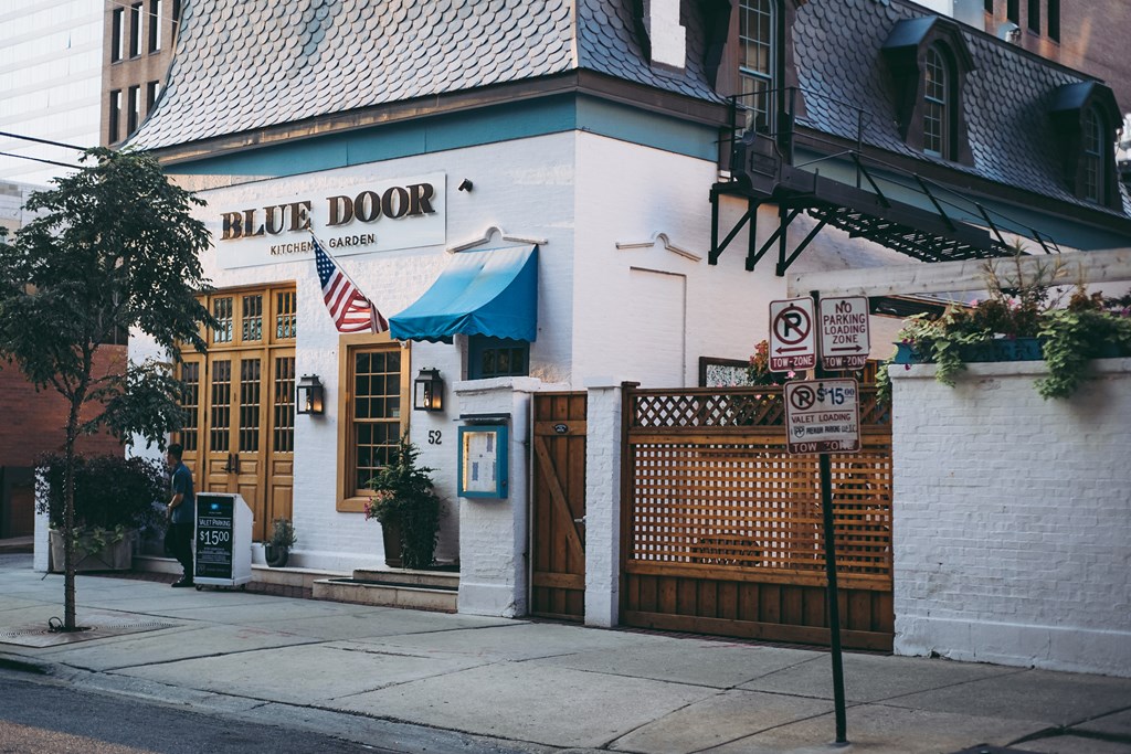 a white building with a blue door on a street