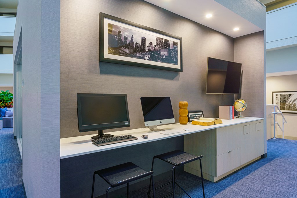a desk with two computers and two chairs in a room