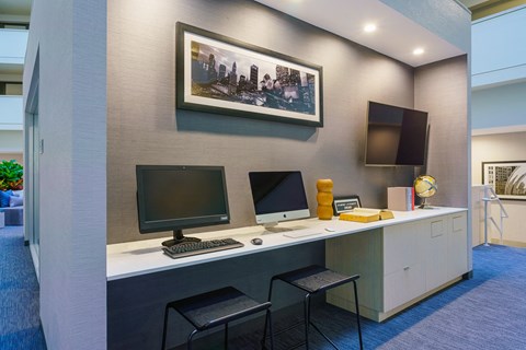 a desk with two computers and two chairs in a room