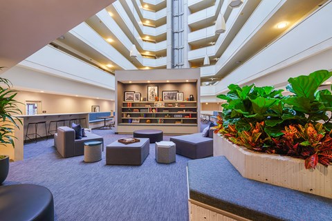 the lobby of a large building with seating and plants