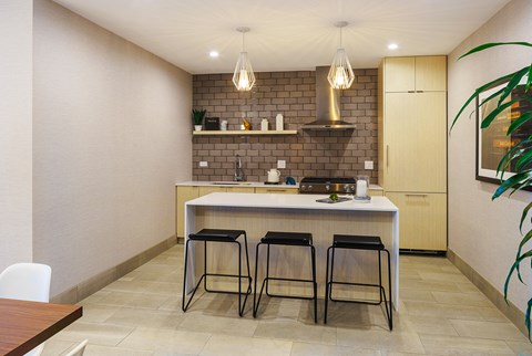 a kitchen with a white counter top and three stools