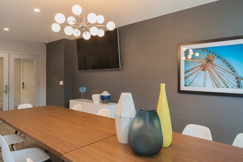 a dining room with a wooden table and a painting on the wall