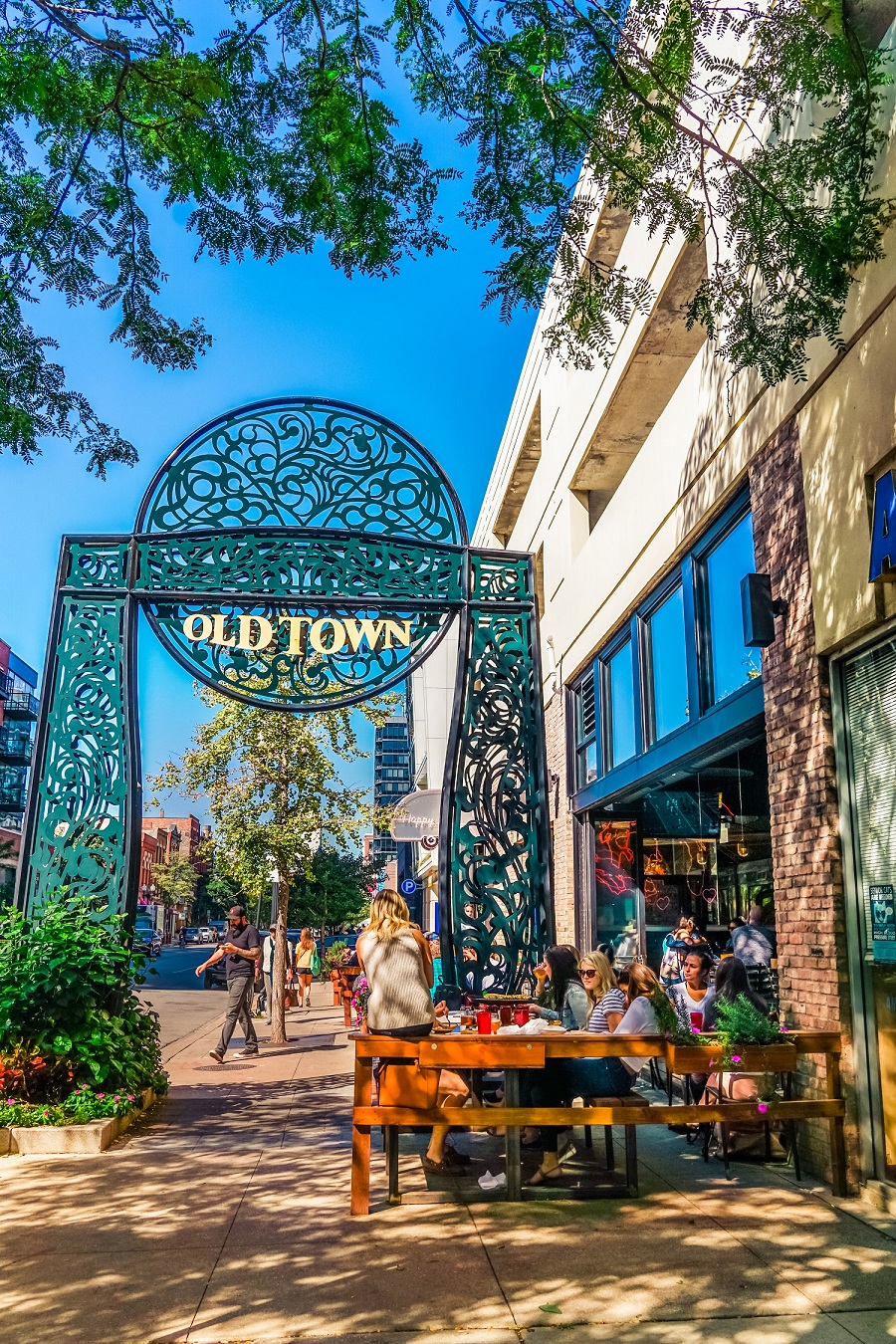 people sitting at tables outside of an old town restaurant on a sidewalk
