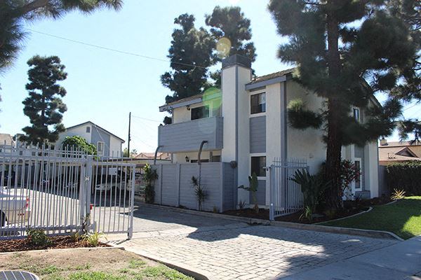 a white house with a white fence and a gate