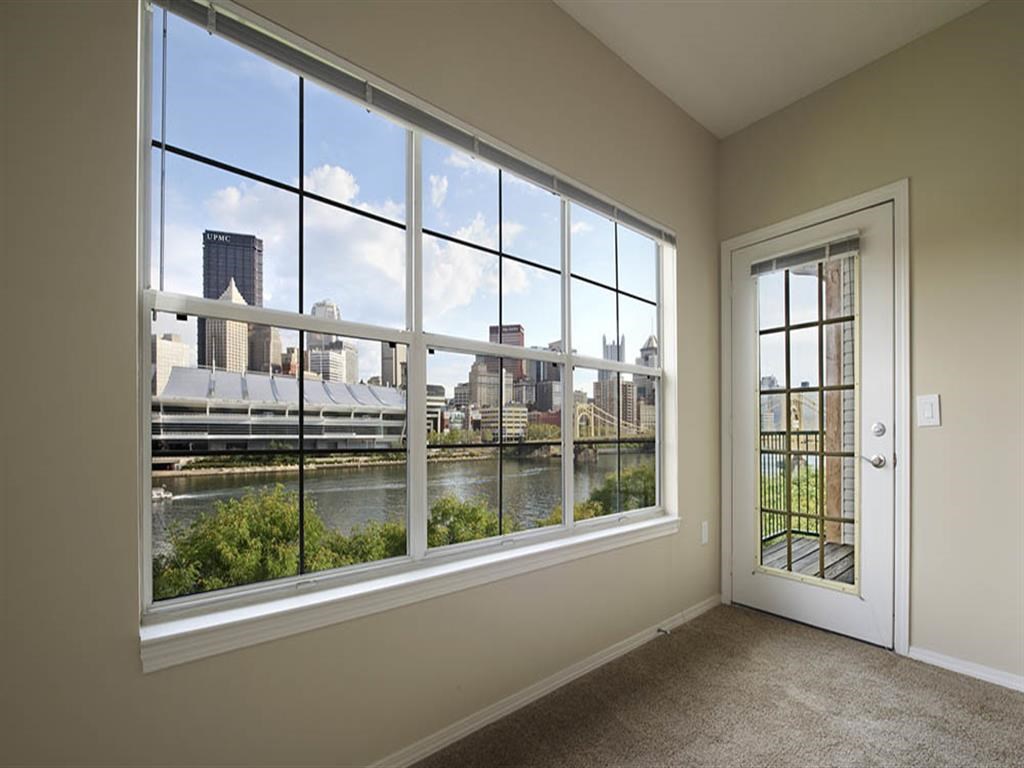 a room with a large window overlooking a river and a city