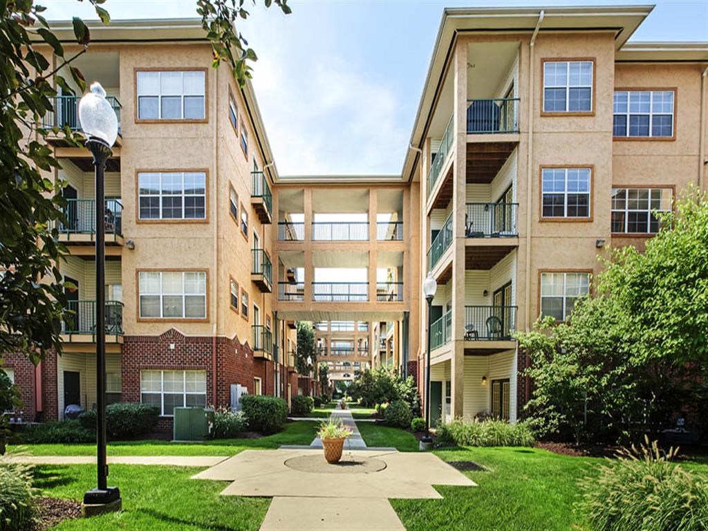 an exterior view of an apartment building with a courtyard