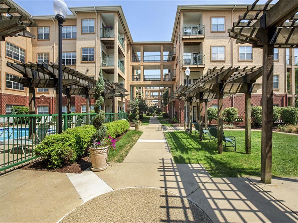 an exterior view of an apartment building with a walkway